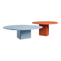 "Round tables in soft blue and vibrant orange with smooth, solid surfaces and geometric bases."
