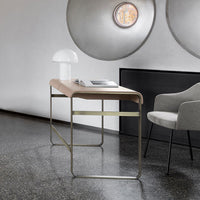 Modern desk featuring a soft pink top and sleek metallic legs, set against a minimalist gray backdrop.