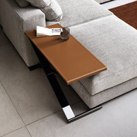 Brown faux leather side table with sleek black metal frame, complementing a contemporary living room aesthetic.