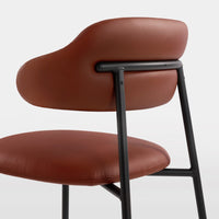 Brown leather chair with a smooth, curved backrest and sleek black metal frame. Modern and stylish design.