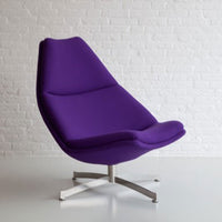Purple lounge chair with a sleek modern design and smooth, contoured upholstery against a white background.