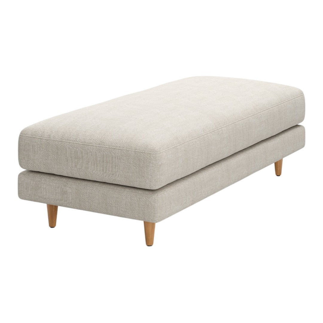 Beige upholstered ottoman with a smooth surface and light wood legs, featuring a minimalist design.