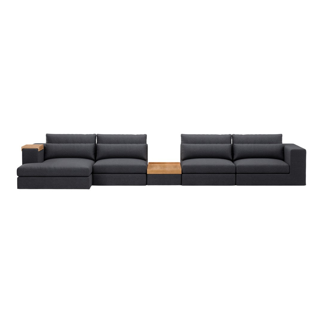 Modern sectional sofa in charcoal gray fabric with plush cushions and a natural wood accent.
