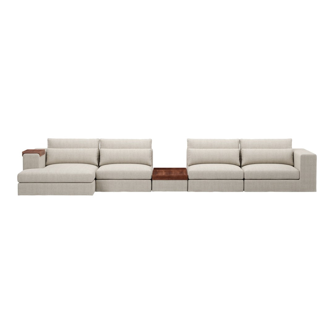 L-shaped sectional sofa in soft beige fabric, featuring plush cushions and a sleek wood accent table.