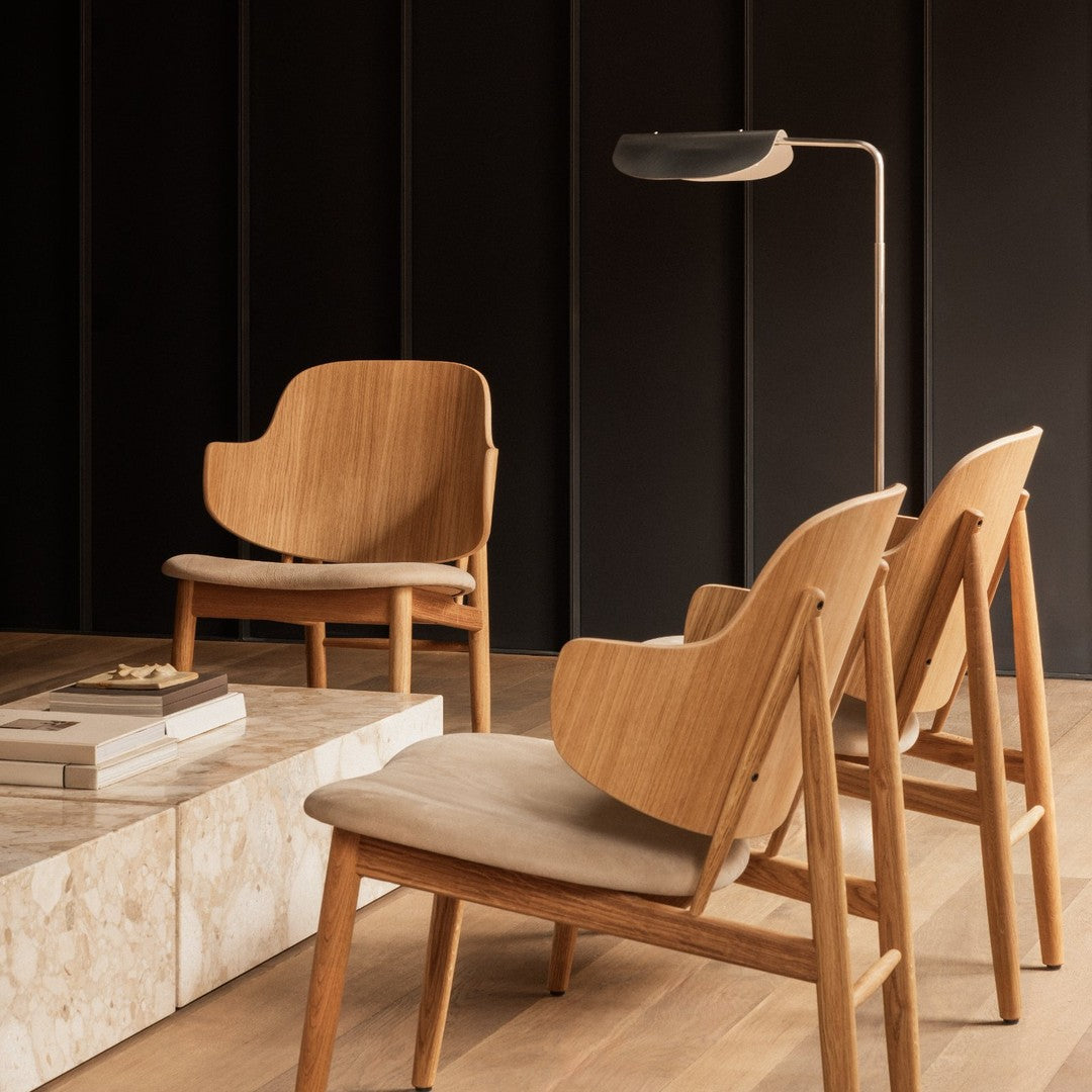 Natural wood tones with a light, beige fabric complement a sleek, modern design in a minimalist setting.