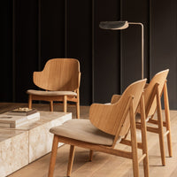 Natural wood tones with a light, beige fabric complement a sleek, modern design in a minimalist setting.