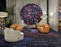 "Modern living room featuring orange sofas, white chair, dark patterned rug, and vibrant circular wall art."