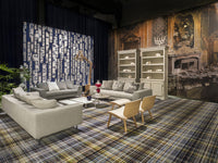 Modern living room with a navy blue patterned accent wall, neutral furniture, and a plaid rug in soft hues.