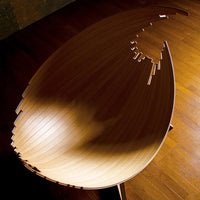 Light wooden bowl with a smooth, glossy finish and intricate curved patterns, showcasing natural grain textures.