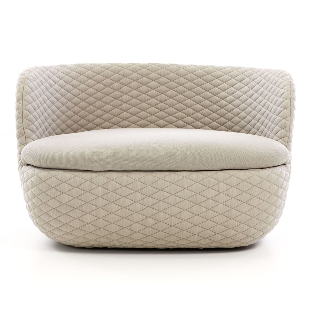 Beige upholstered chair with a quilted diamond pattern and smooth, rounded edges. Ideal for modern interiors.