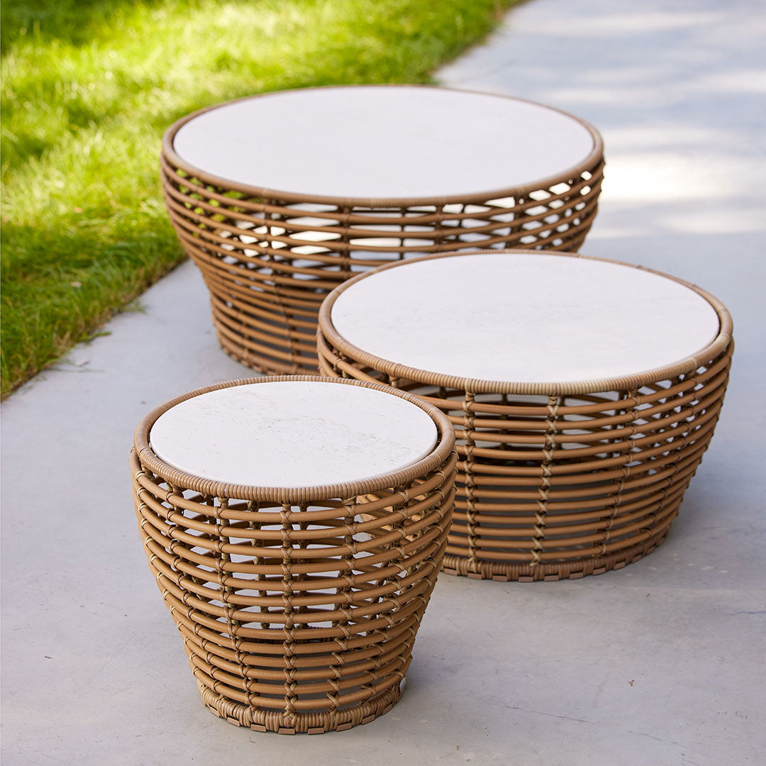 Natural rattan coffee tables in varying sizes, featuring woven patterns and light-colored round tabletops.