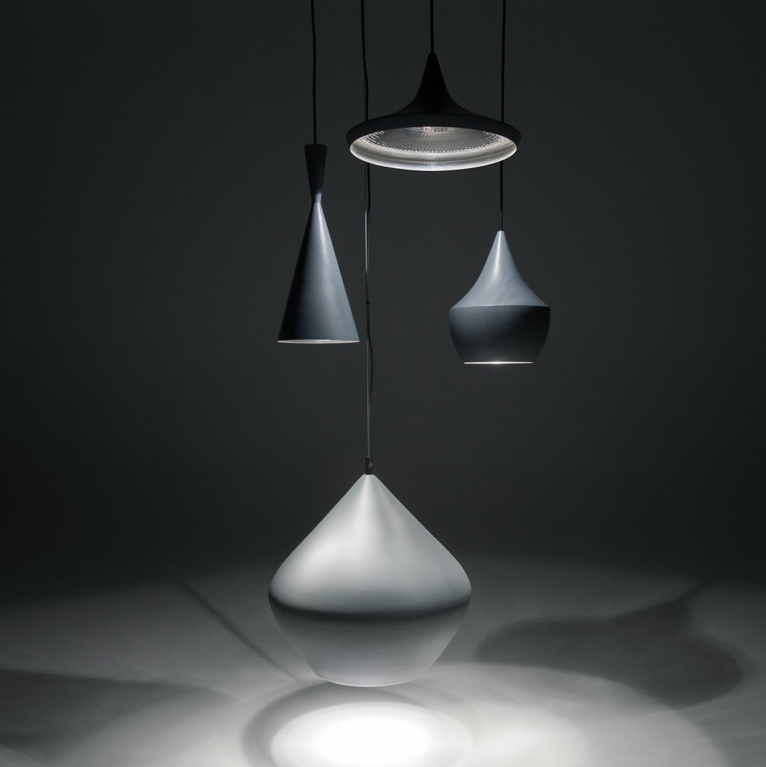 Three modern pendant lamps in varying shades of grey, featuring sleek, minimalist shapes and smooth finishes.