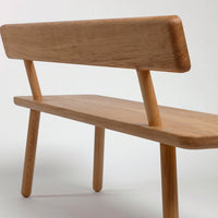 Light oak wood bench with a smooth finish and minimalist design, featuring clean lines and natural grain patterns.