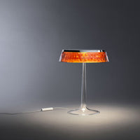 Stylish lamp with a clear base and an eye-catching orange patterned shade, perfect for modern decor.