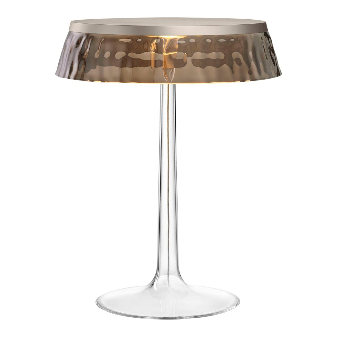 Modern transparent lamp with a hammered gold and silver shade, featuring a minimalist design and elegant curves.