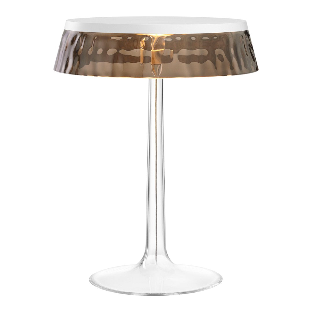 Modern lamp with a clear base and a patterned bronze shade, adding elegance to any decor.