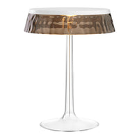 Modern lamp with a clear base and a patterned bronze shade, adding elegance to any decor.