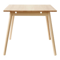 Light wood dining table with a clean, minimalist design and natural finish, showcasing smooth grain patterns.