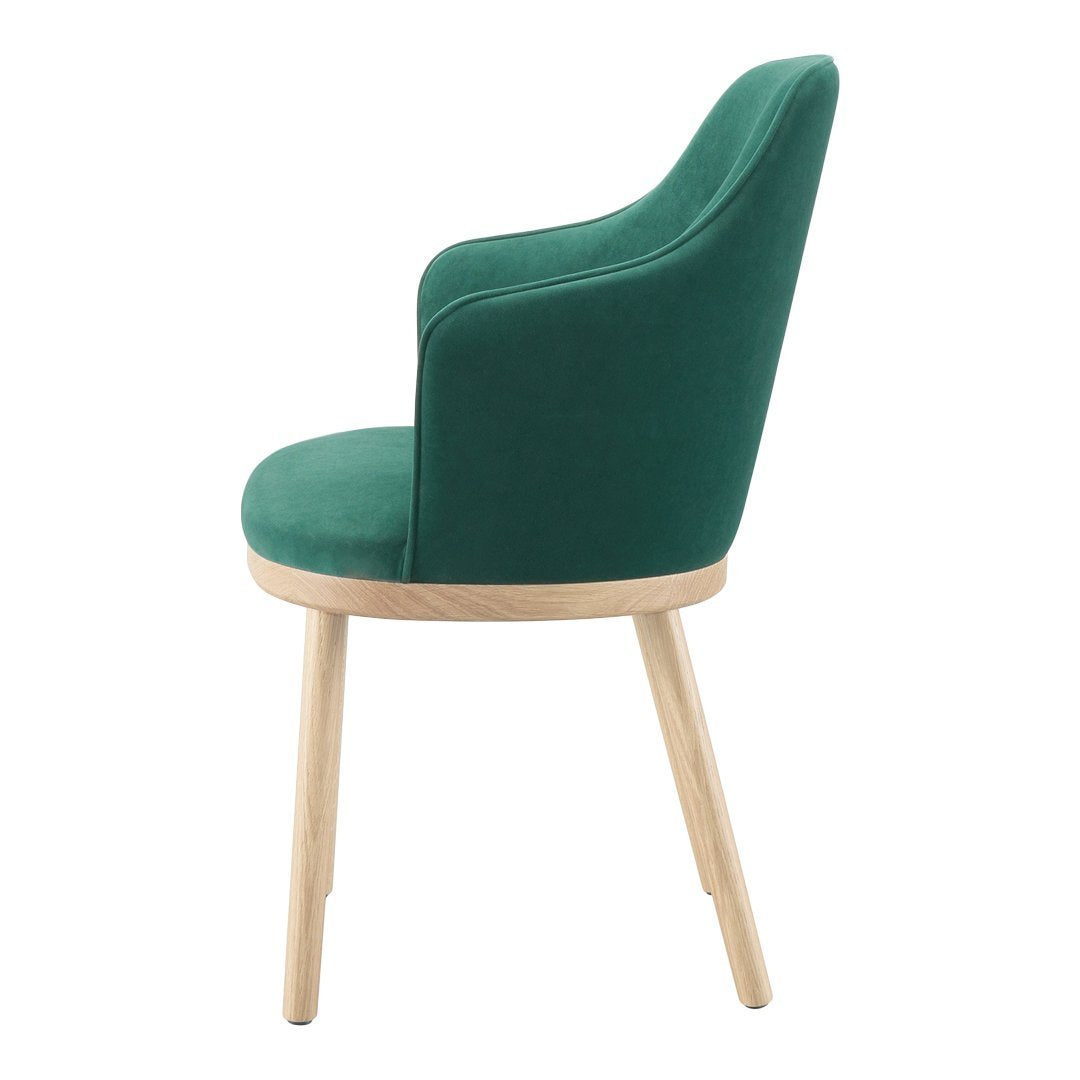 Green velvet chair with a smooth, curved back and natural wood legs, adding a stylish touch to any space.
