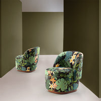Tropical-patterned accent chairs in vibrant greens and yellows, set against a muted olive green backdrop.