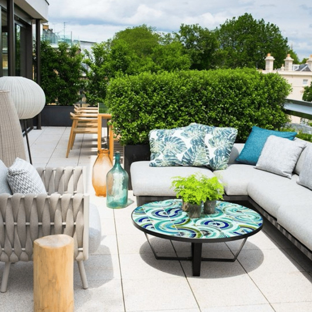 "Grey and teal outdoor sofa set with decorative blue and green patterned cushions and a colorful patterned coffee table."