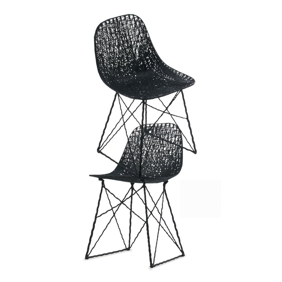 Two black woven chairs stacked, featuring intricate lattice patterns and sleek metal legs.