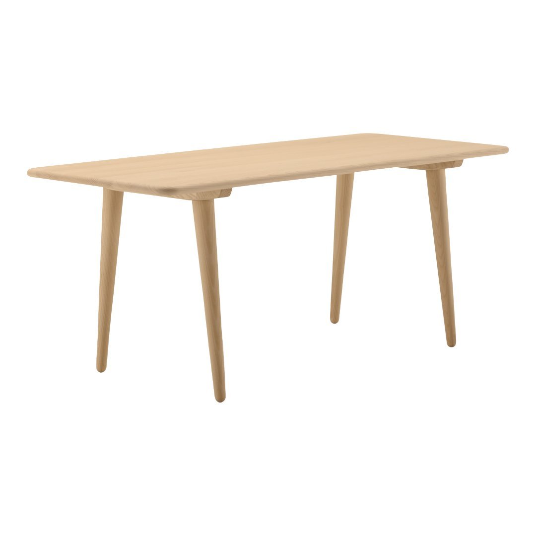 Natural wood dining table with a smooth beige finish and minimalist design, featuring tapered legs and a rectangular top.