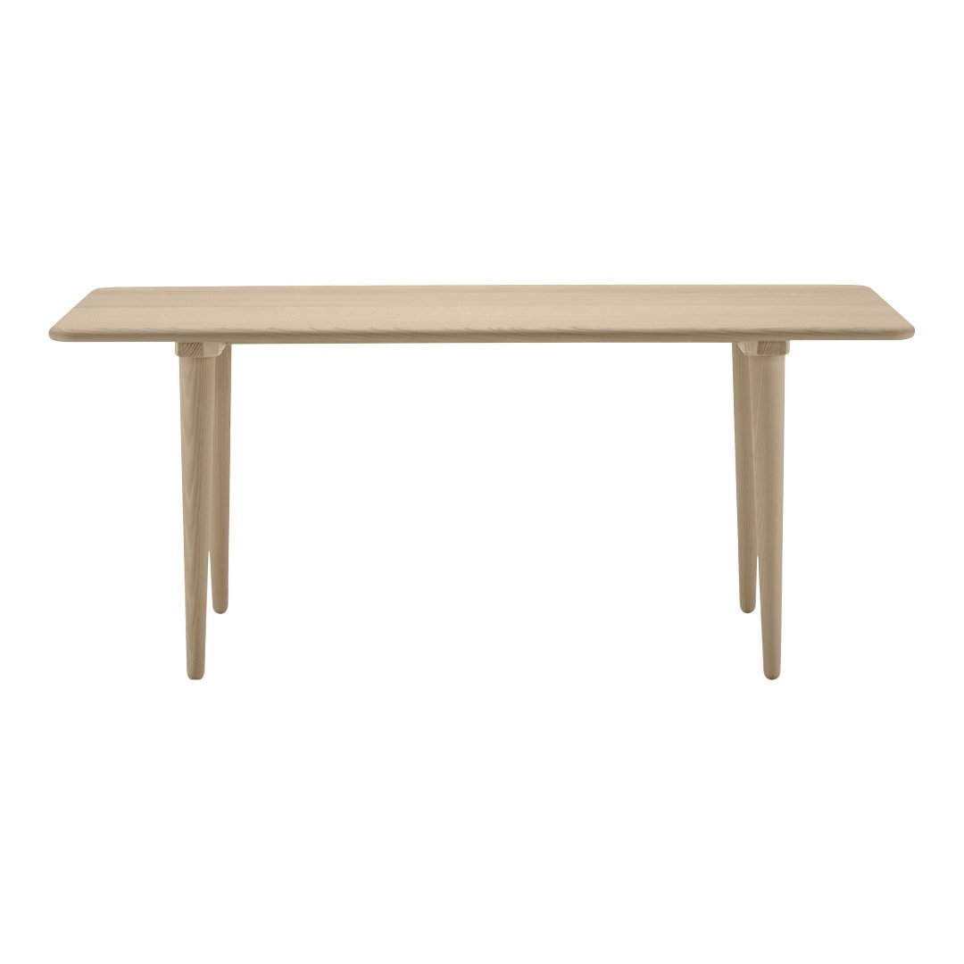 Beige rectangular table with smooth surface and tapered legs, showcasing a minimalist design and neutral color palette.
