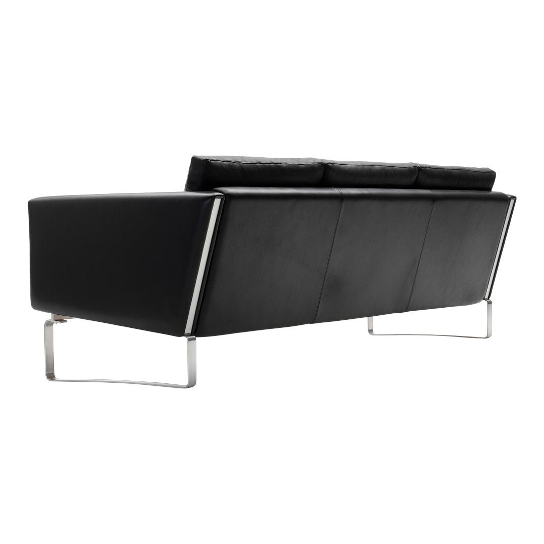 "Modern black leather sofa with sleek lines and stainless steel legs, featuring a minimalist design and no visible patterns."