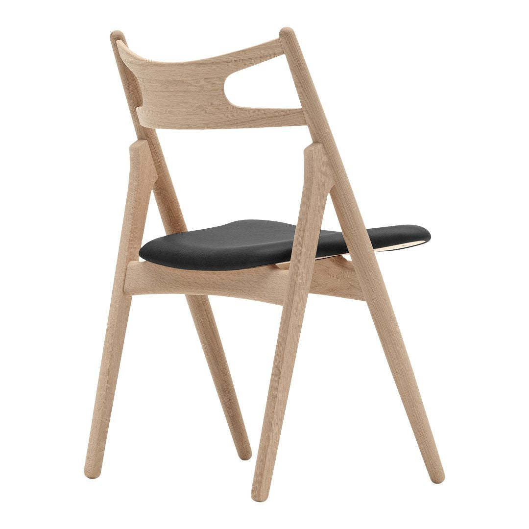 Light wood chair with a sleek black cushion and a minimalist design, featuring an elegant, natural finish.