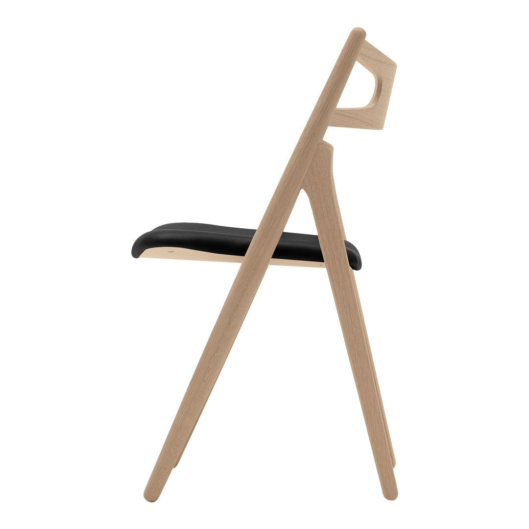 "Minimalist wooden chair with a natural finish and a sleek black seat, showcasing modern design and clean lines."