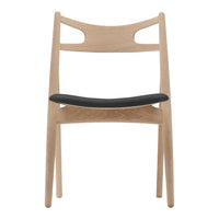 Light wood chair with a minimalist design featuring a black upholstered seat and smooth natural finish.