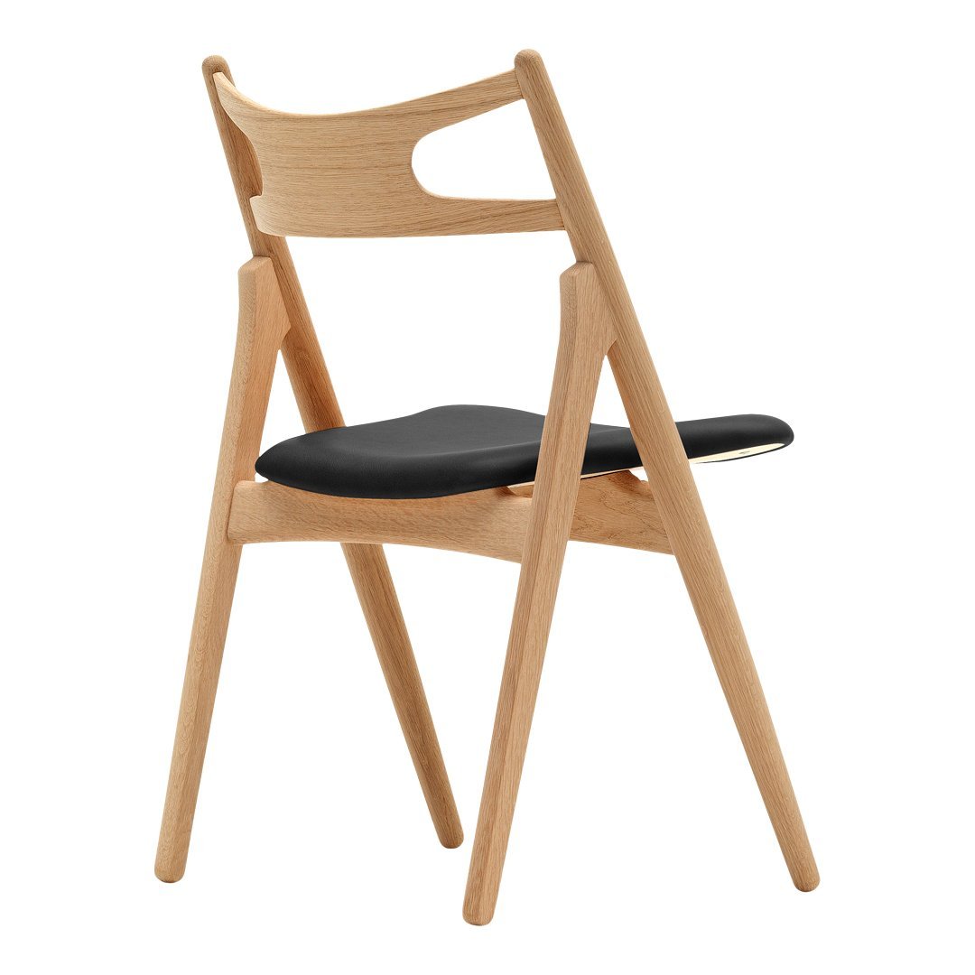 Wooden chair with a natural finish and sleek black seat, featuring a minimalist design and smooth lines.