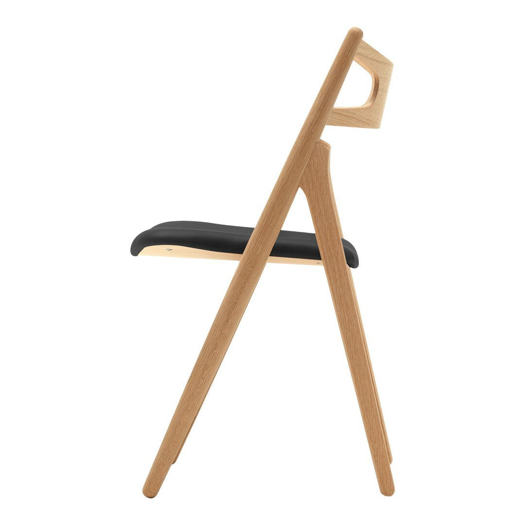 Oak wooden chair with a sleek black seat, showcasing a minimalist design and natural finish. Perfect for modern decor.