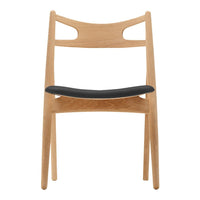Natural wood chair with a light oak finish and a sleek black seat, featuring minimalist design and smooth lines.