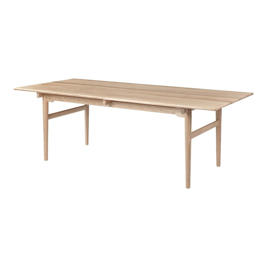 Natural wood grain dining table with a smooth, light beige finish and simple, clean lines.