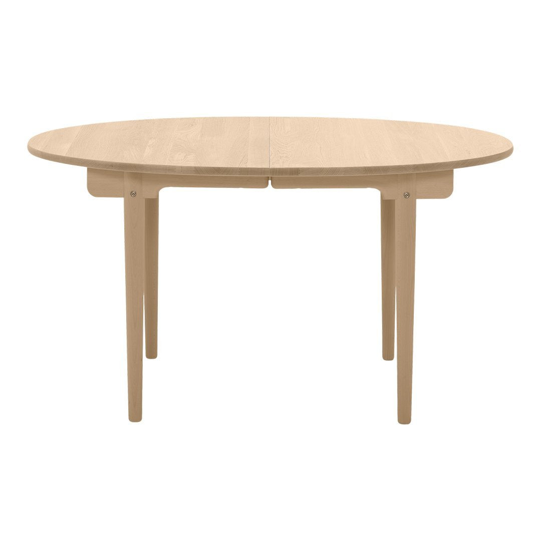 Light natural wood oval dining table with smooth finish and minimalist design, perfect for modern interiors.