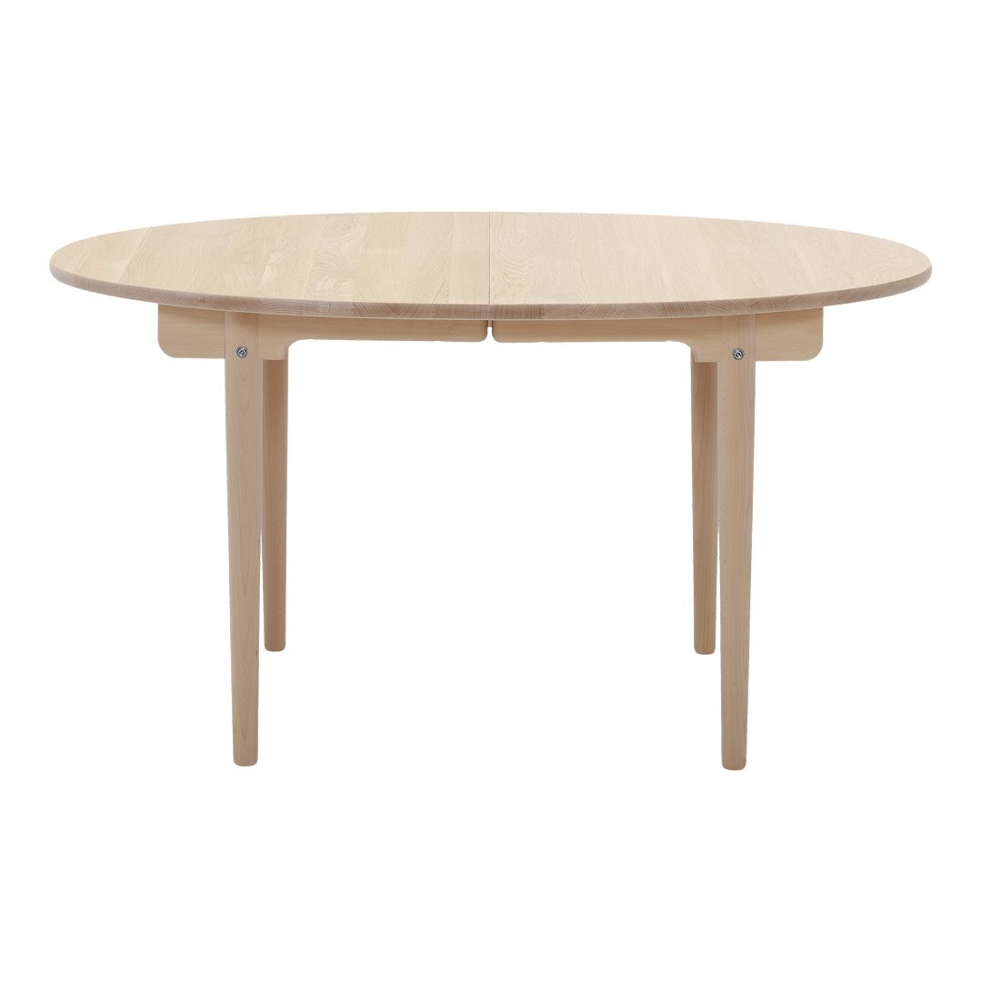 Natural wood round dining table with a smooth finish and minimalist design. Light beige color enhances any decor.