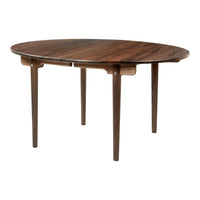 Round wooden table with a rich walnut finish and smooth surface, featuring minimalist design and tapered legs.