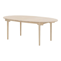 Light wood oval dining table with smooth finish and minimalistic design, showcasing natural grain patterns.