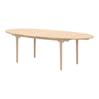 Natural wood dining table with a sleek, oval design and light beige finish, featuring smooth, minimalist lines.