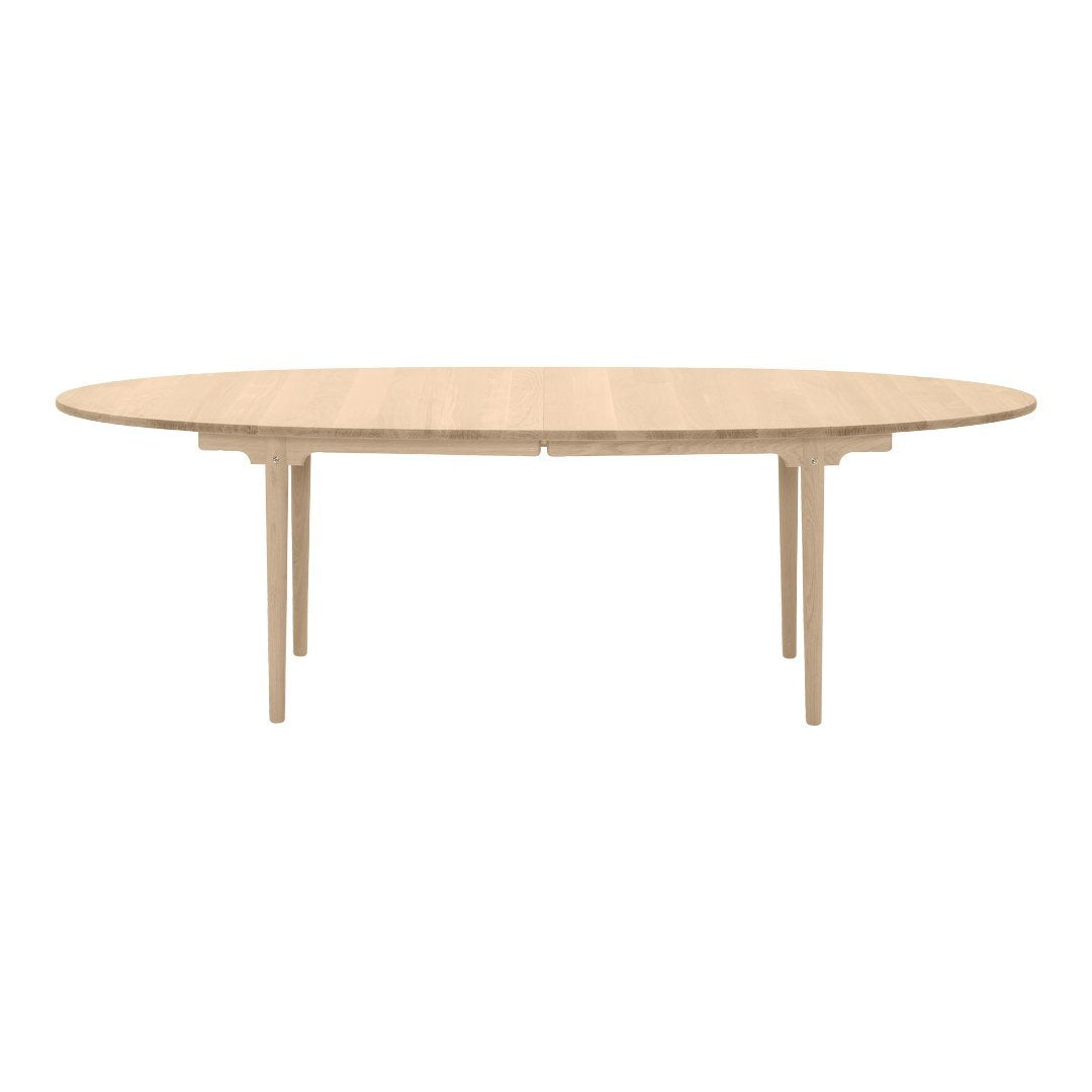 Light oak oval dining table with a smooth finish and elegant wood grain pattern. Perfect for modern interiors.