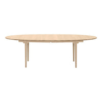 Light oak oval dining table with a smooth finish and elegant wood grain pattern. Perfect for modern interiors.