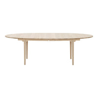 Light wood oval dining table with a smooth finish and minimalist design, showcasing natural wood grain patterns.