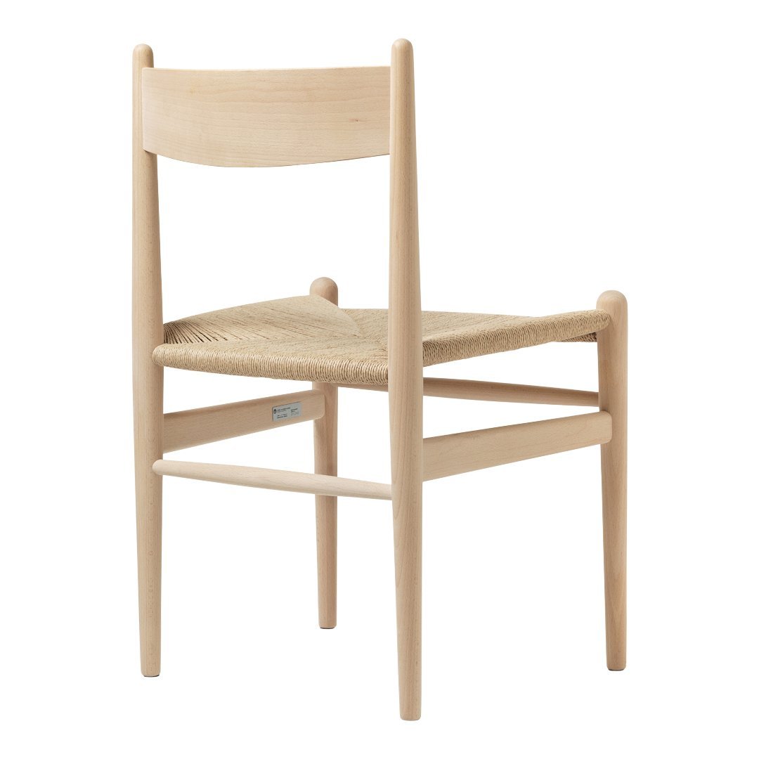 Natural wood chair with a light, minimalist design and woven seat in beige tones. Simple and elegant aesthetic.