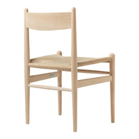 Natural wood chair with a light, minimalist design and woven seat in beige tones. Simple and elegant aesthetic.