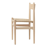 Minimalist natural wood chair with a woven straw seat, showcasing soft beige tones and smooth, simple lines.