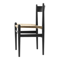 Black wooden chair with a natural woven seat, showcasing a minimalist design and elegant color contrast.