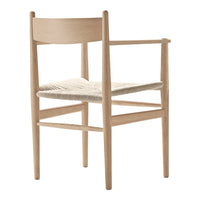 Light wood chair with a natural woven seat, showcasing a minimalist design and soft, neutral tones.