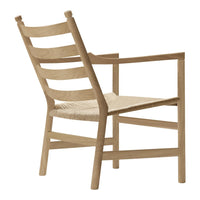 Light wood chair with a woven seat, featuring a minimalist design and natural finish, ideal for modern decor.